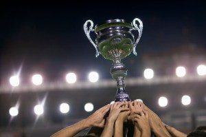 Soccer Team Raising Trophy